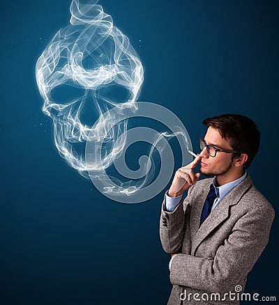 Young man smoking dangerous cigarette with toxic skull smoke Stock Photo