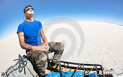 Young man solo traveler taking relax break at Salar de Uyuni Bolivia Stock Photo