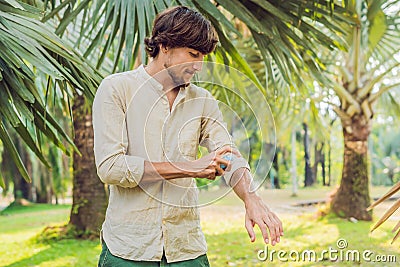 Young man spraying mosquito insect repellent in the forrest, insect protection Stock Photo