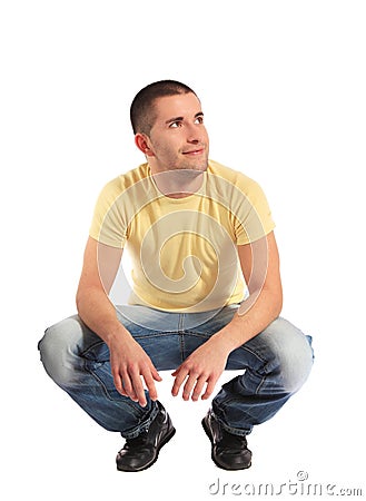 Young man in squatting position Stock Photo