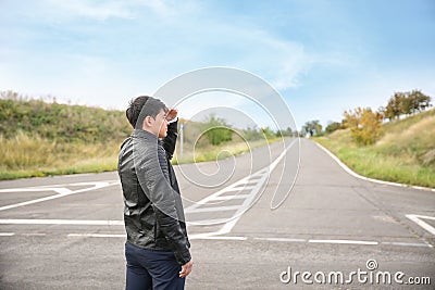 Young man standing at crossroads. Concept of choice Stock Photo
