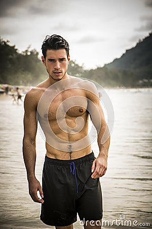 Young man standing on edge of the ocean Stock Photo