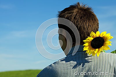 Young man standing with a sunflower Stock Photo