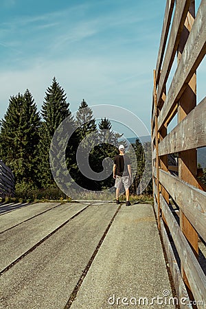 Young man standing on top of wood crossover, Sumava National Park, Czech republic and Germany Stock Photo
