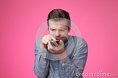 Young man standing, using smartphone and watching video with amazed face. Stock Photo