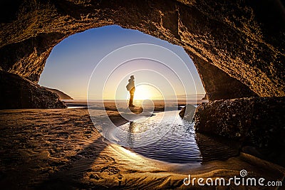 Man deep thinking inside wharariki beach cave in New Zealand Stock Photo