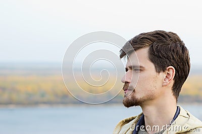 A young man stands outdoor. Stock Photo