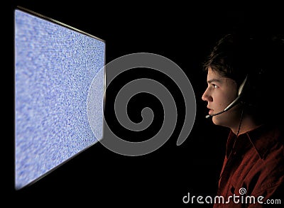 Young man staring into static TV Computer screen Stock Photo