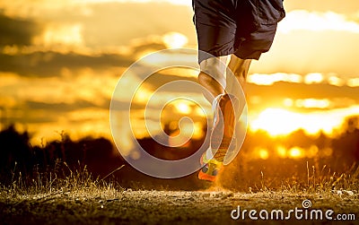 Young man strong legs off trail running at amazing summer sunset in sport and healthy lifestyle Stock Photo