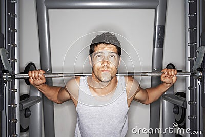 Young Man Struggling To Lift Weights Stock Photo