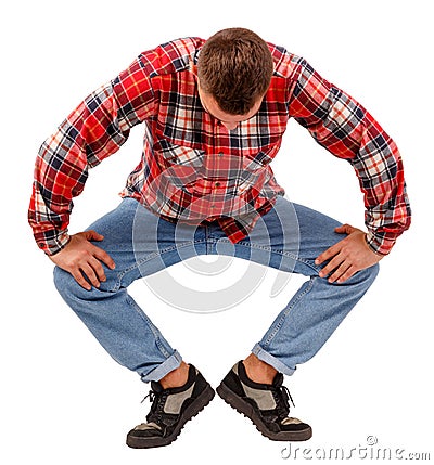 Young man performing plie on the first swivel position, in a checkered shirt, isolated on white background Stock Photo