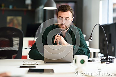 Young man studying with laptop computer on white desk. Stock Photo