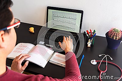 Young man studying medicine sitting at a desk Stock Photo