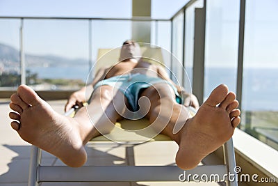 Young man sun tanning in a sunlounger Stock Photo