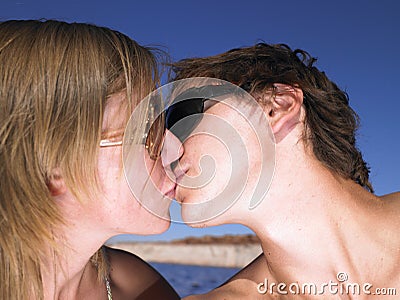 Young Man in Sunglasses Kissing Woman Stock Photo