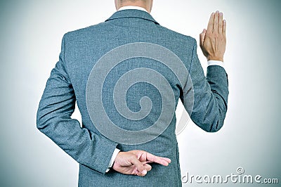 Young man swearing an oath, crossing his fingers in his back Stock Photo