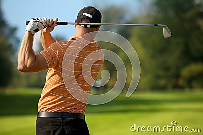 Young man swinging golf club, rear view Stock Photo