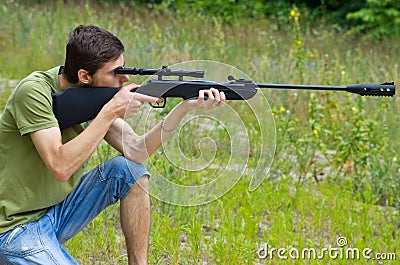 Young man taking aim with the air rifle Stock Photo