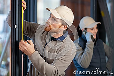 young man taking measure window for blinds installation Stock Photo