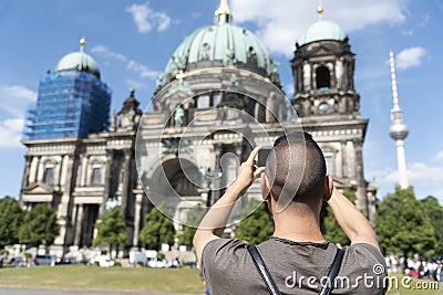 Young man taking a picture of the Berlin Cathedral Stock Photo