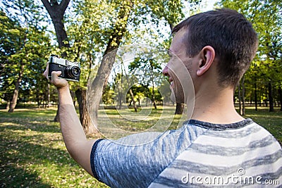 Young man taking selfie on retro camera Stock Photo