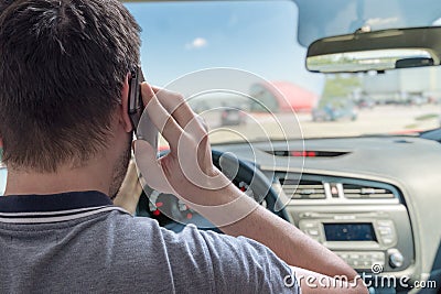 Young man is telephoning in car with smartphone Stock Photo