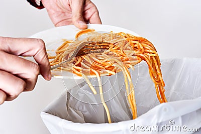 Young man throwing leftovers to the trash bin Stock Photo