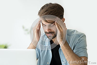 Young man touching temples trying to focus or feeling headache Stock Photo