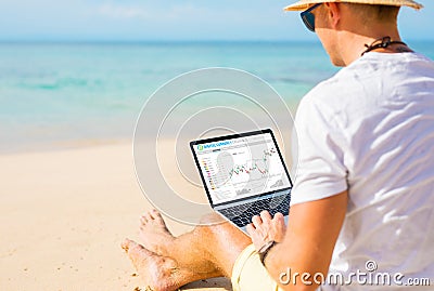 Man trading cryptocurrencies on the beach. Stock Photo