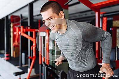 A young man trains in the gym, shakes on the gym triceps and bic Stock Photo