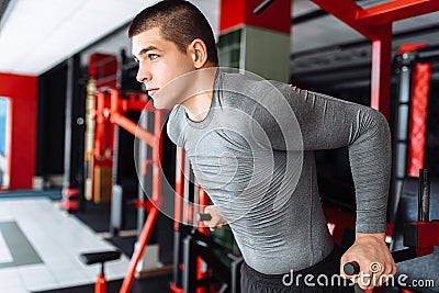 A young man trains in the gym, shakes on the gym triceps and bic Stock Photo