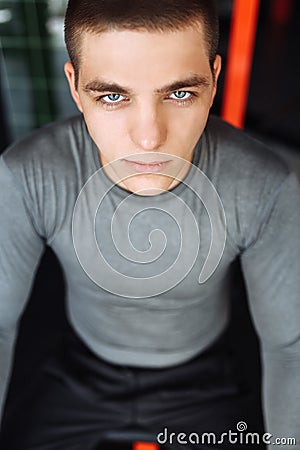 A young man trains in the gym, shakes on the gym triceps and biceps Stock Photo