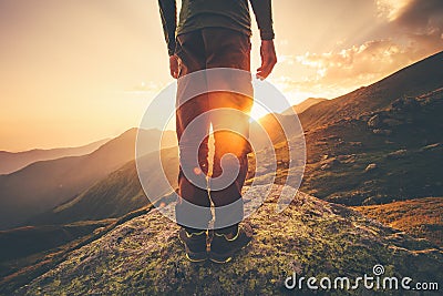 Young Man Traveler feet standing alone with sunset mountains on background Stock Photo