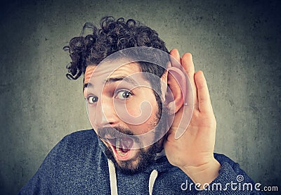 Young man tries to listen carefully Stock Photo