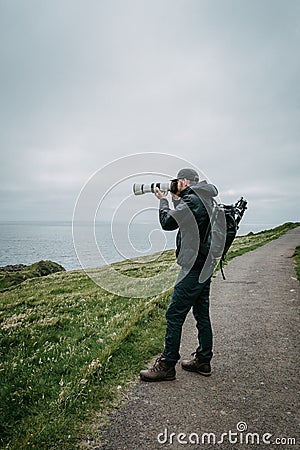 Young man trourist traveler hiking. Tjornuvik beautiful town in the Faroe Islands, sit on the north coast of Streymoy Stock Photo