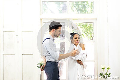 Young man trying to reconcile his girlfriend offering white rose Stock Photo