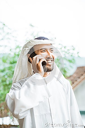 man in a turban is calling using a mobile phone while smiling Stock Photo