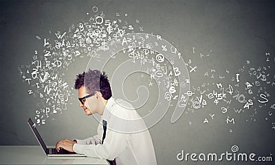 Young man typing on laptop computer alphabet letters flying away Stock Photo