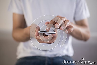 Young man using touchscreen smartphone. Concept for using technology, shopping online, using mobile apps, texting, phone addiction Stock Photo