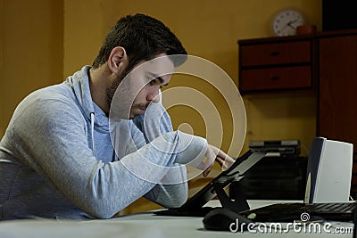 Young man using his mobile, tablet, laptop and headphones Stock Photo