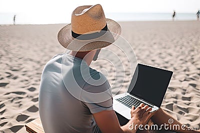 Young man using laptop computer on a beach. Freelance work concept Stock Photo