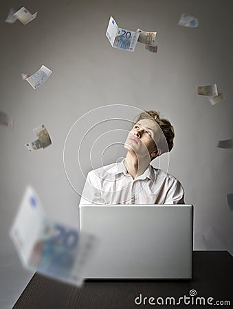 Young man with laptop. Young worker and falling Euro banknotes Stock Photo