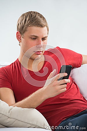 Young man using mobile phone to send messages Stock Photo