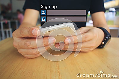 Young man using smart phone and sign up or log in username password on the wooden table in restaurant, GDPR.cyber security and Stock Photo