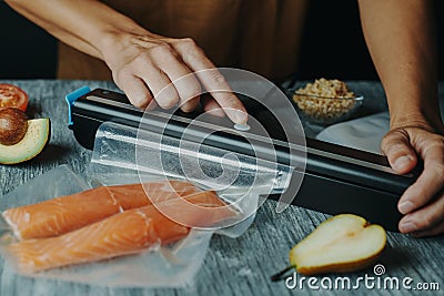 Man vacuum-packs salmon in a vacuum bag Stock Photo