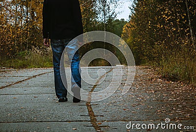Young man walk on panel path in autumn forest, colored photo Stock Photo