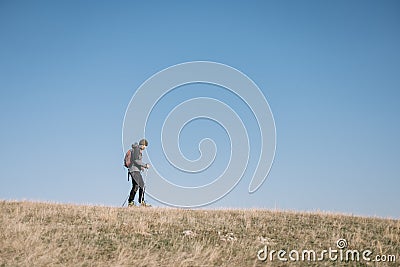 Young man walking on a hill with blue heavens Stock Photo