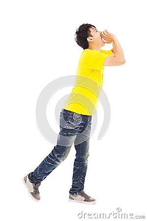 Young man walking while raising hands to yell Stock Photo