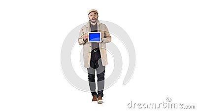 Young man walking, talking and showing digital tablet with blue screen mockup on white background. Stock Photo