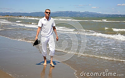 A young man walks along the Balearic Sea at Riumar beach in Spain Stock Photo